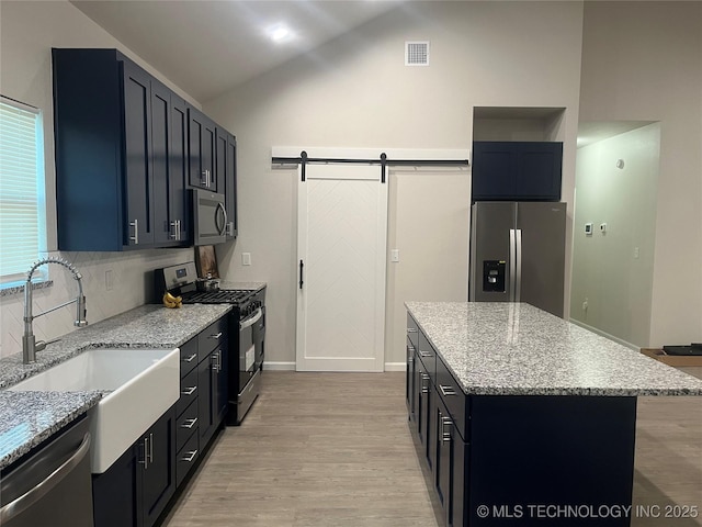 5114 W 3rd St, Tulsa, OK 74127 - kitchen with visible vents, light wood-type flooring, a sink, vaulted ceiling, and stainless steel appliances