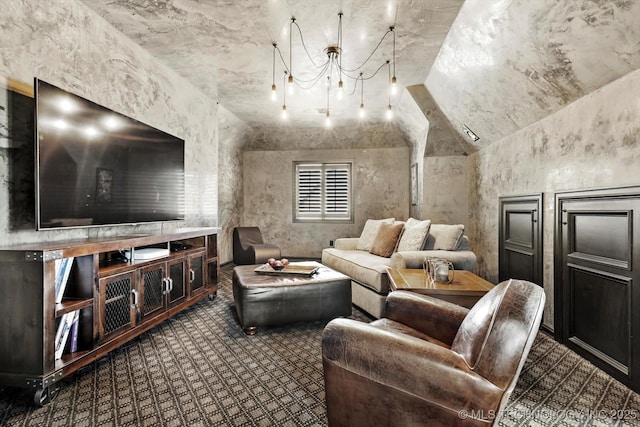 carpeted home theater with vaulted ceiling and a chandelier