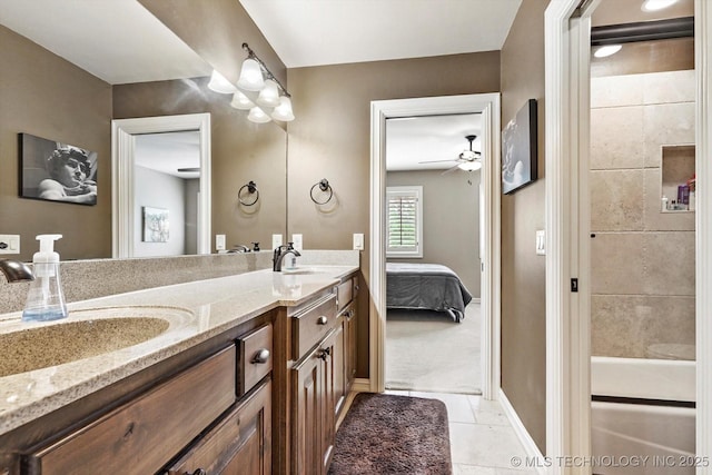 bathroom featuring connected bathroom, double vanity, baseboards, and a sink