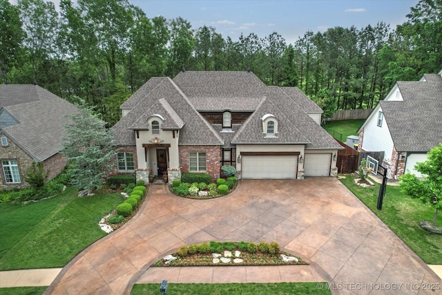 french country style house with a garage, a shingled roof, driveway, and a front lawn