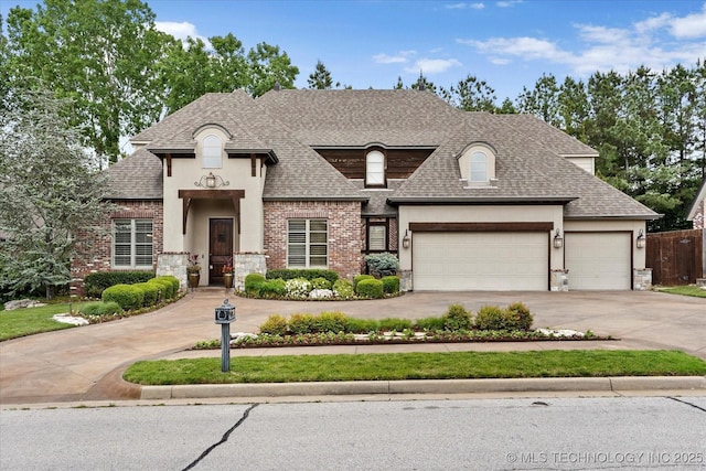 french country inspired facade featuring driveway, a garage, a shingled roof, stone siding, and stucco siding