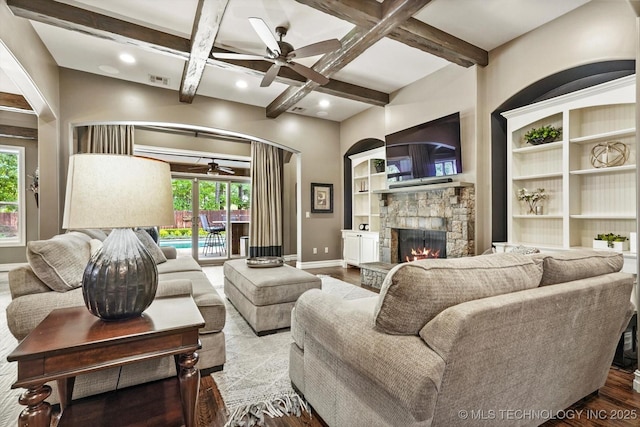 living room with a ceiling fan, coffered ceiling, a healthy amount of sunlight, and a fireplace