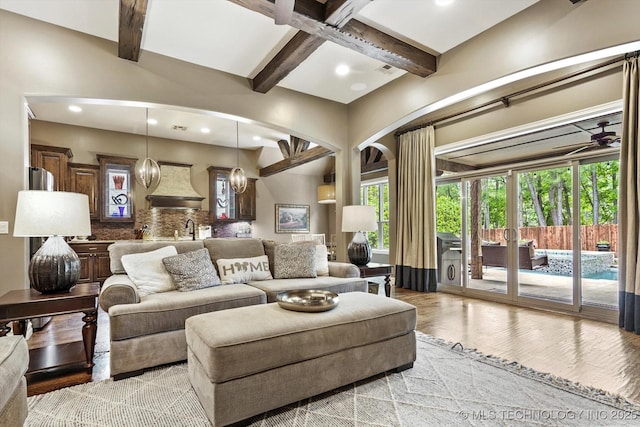 living room featuring recessed lighting, light wood finished floors, and beam ceiling