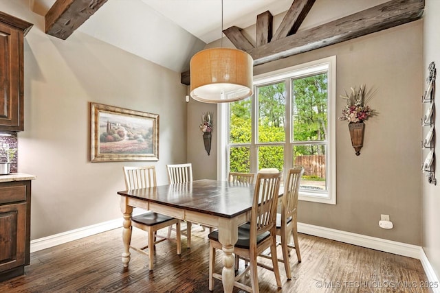 dining space with baseboards, lofted ceiling with beams, and wood finished floors
