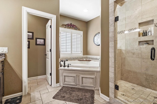 bathroom with baseboards, a stall shower, a garden tub, and stone tile floors