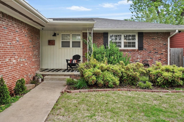 5729 E 25th Pl, Tulsa, OK 74114 - view of exterior entry featuring a lawn, brick siding, and fence