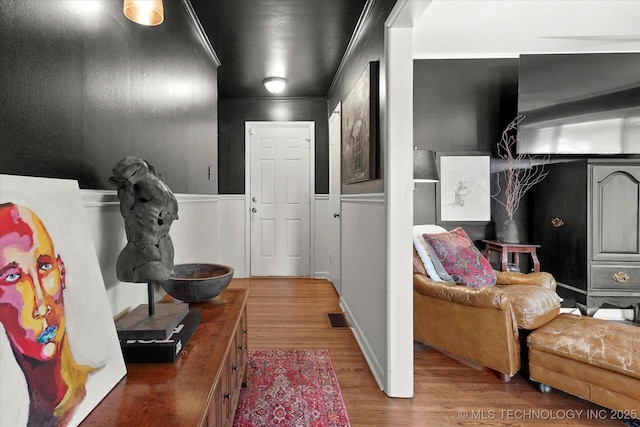 5729 E 25th Pl, Tulsa, OK 74114 - hall with a wainscoted wall, a decorative wall, wood finished floors, and visible vents