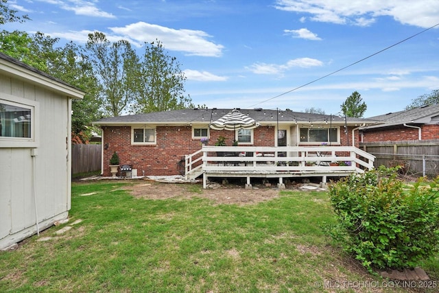5729 E 25th Pl, Tulsa, OK 74114 - rear view of house featuring fence, a wooden deck, a lawn, and brick siding
