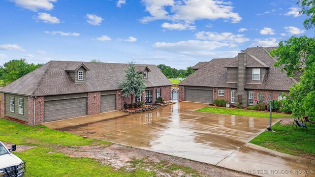 view of front of home featuring concrete driveway, a front lawn, and brick siding