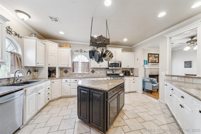 kitchen with backsplash, visible vents, appliances with stainless steel finishes, a sink, and white cabinetry