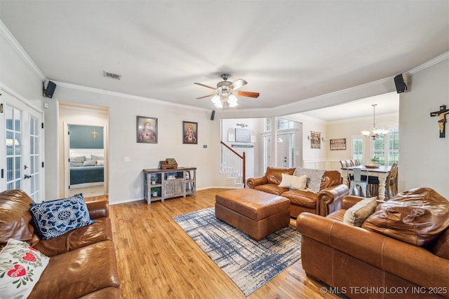 living area featuring ornamental molding, stairs, wood finished floors, and visible vents