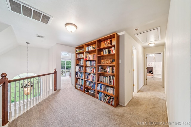 corridor featuring visible vents, carpet, and attic access
