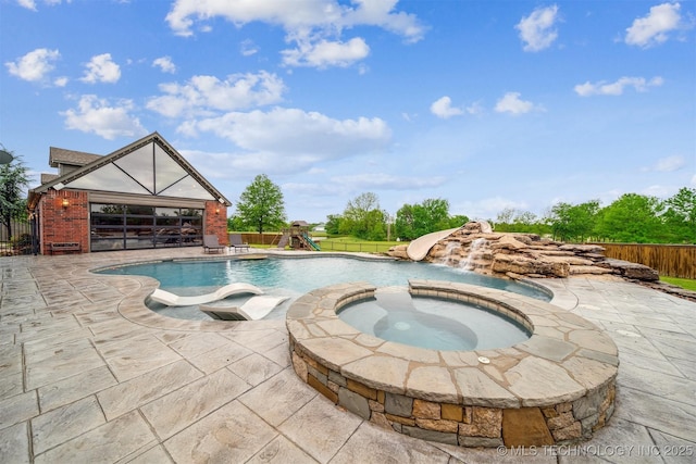 view of swimming pool with fence, a playground, a patio area, and a pool with connected hot tub