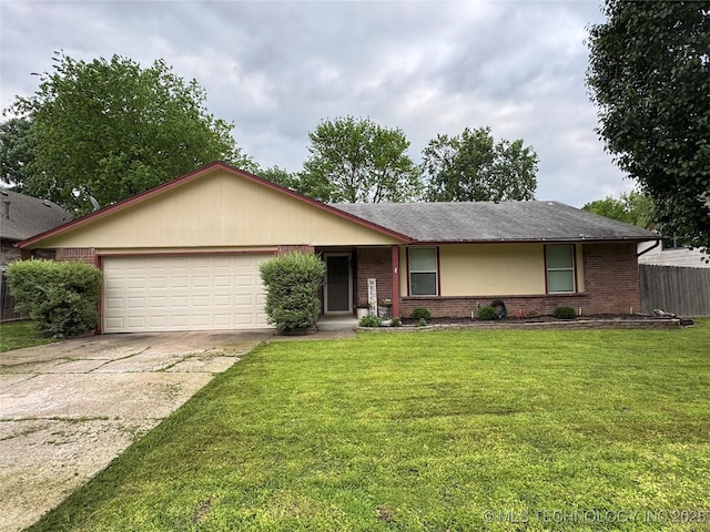ranch-style home featuring a garage, a front lawn, fence, brick siding, and concrete driveway