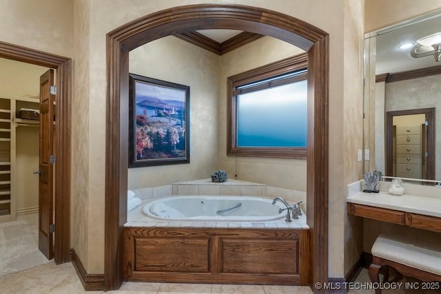 bathroom with baseboards, ornamental molding, a bath, and a spacious closet