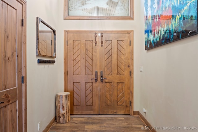 entryway featuring baseboards and wood finished floors