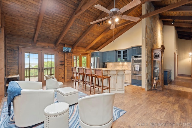 living room with beamed ceiling, high vaulted ceiling, wooden ceiling, and french doors