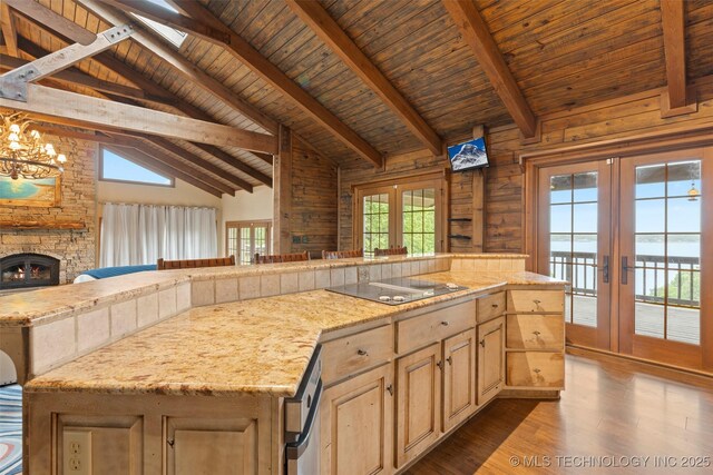 kitchen with dark wood-style flooring, black electric stovetop, beam ceiling, french doors, and wooden ceiling