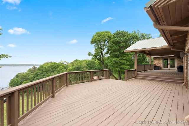 wooden deck with a water view and french doors