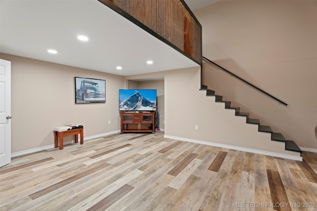 below grade area featuring recessed lighting, stairs, light wood finished floors, and baseboards
