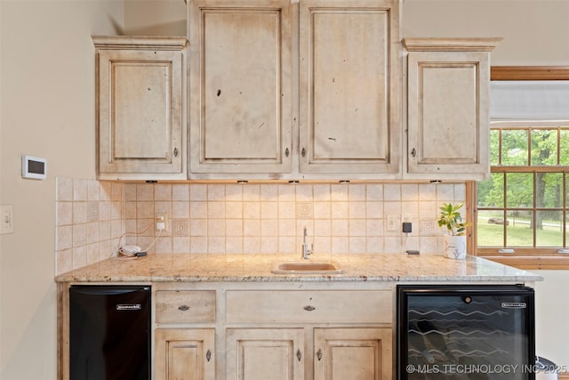 kitchen with a sink, light brown cabinetry, backsplash, and wine cooler