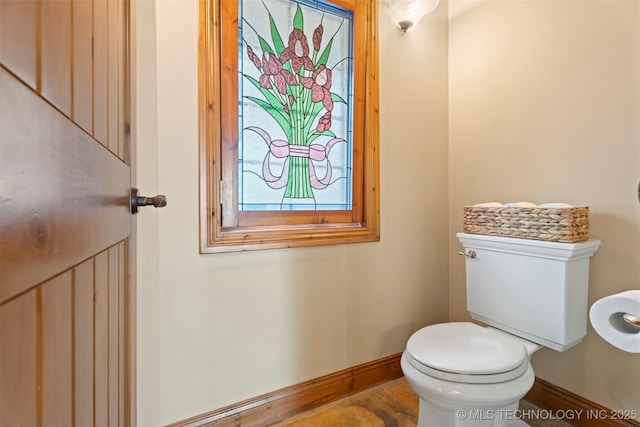 bathroom featuring toilet and baseboards