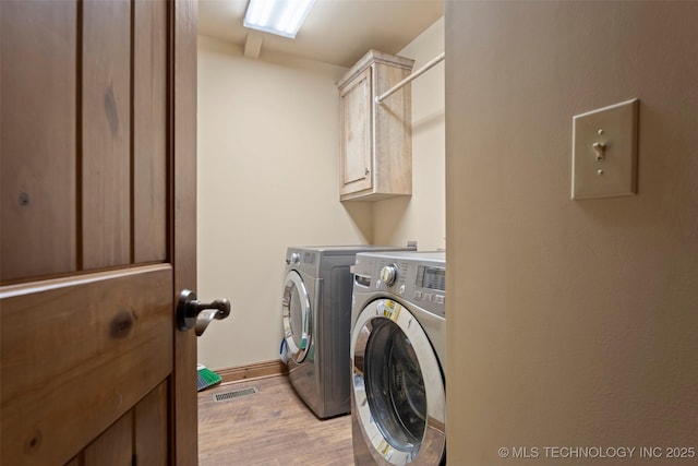 laundry area with independent washer and dryer, visible vents, cabinet space, baseboards, and light wood-style flooring