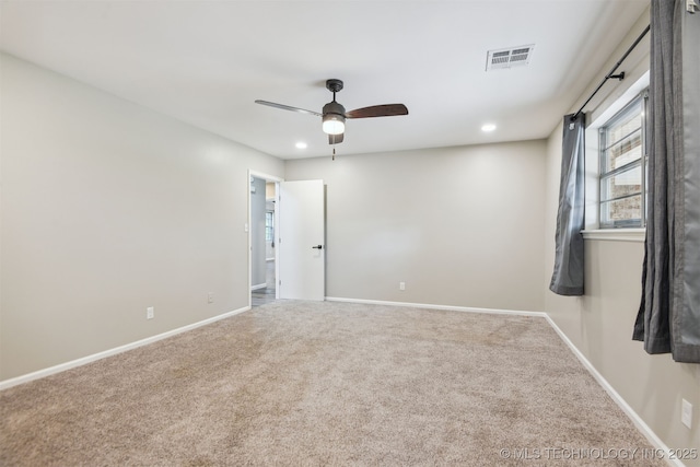 unfurnished room with baseboards, a ceiling fan, carpet flooring, and visible vents