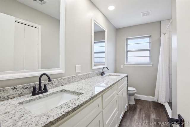 full bathroom with toilet, baseboards, a sink, and wood finished floors
