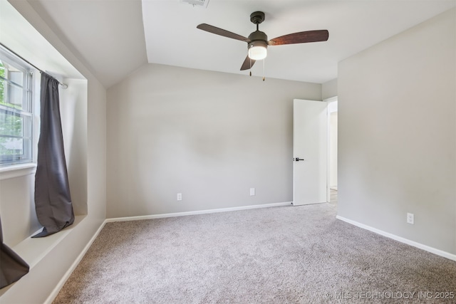 carpeted empty room featuring baseboards, ceiling fan, lofted ceiling, and visible vents