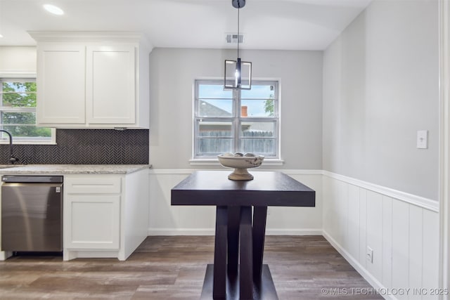 interior space featuring stainless steel dishwasher, white cabinets, and a wealth of natural light