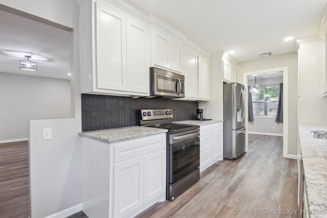 kitchen with stainless steel appliances, baseboards, white cabinetry, backsplash, and visible vents