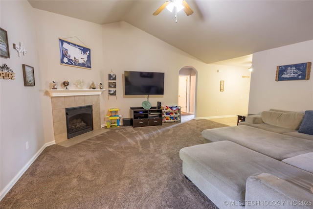 living area featuring arched walkways, ceiling fan, carpet, and vaulted ceiling