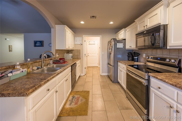 kitchen featuring white cabinets, a sink, stainless steel appliances, tasteful backsplash, and visible vents