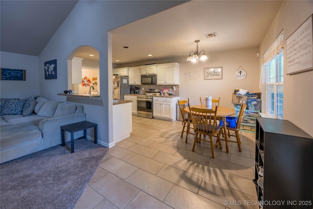 dining area with a chandelier, recessed lighting, light tile patterned floors, vaulted ceiling, and visible vents