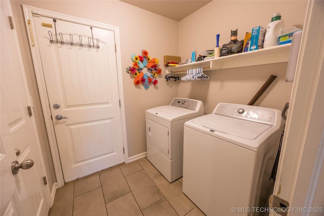 laundry area featuring light tile patterned floors, baseboards, laundry area, and washer and clothes dryer