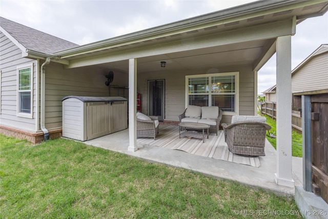 rear view of house with fence, a patio, roof with shingles, an outdoor living space, and a lawn