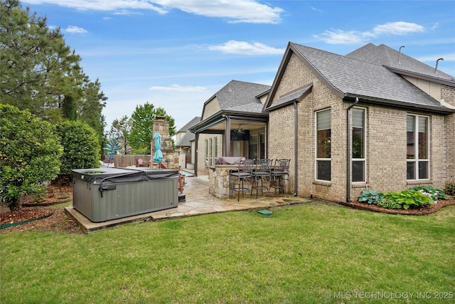 back of house featuring roof with shingles, a patio area, outdoor dry bar, a hot tub, and brick siding