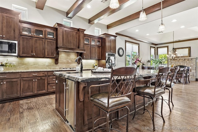 4401 S Quinoa Ave, Broken Arrow, OK 74011 - kitchen with stainless steel appliances, wood finished floors, backsplash, an island with sink, and pendant lighting