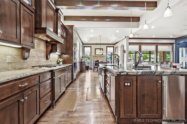4401 S Quinoa Ave, Broken Arrow, OK 74011 - kitchen with light wood finished floors, stone counters, backsplash, beamed ceiling, and an island with sink