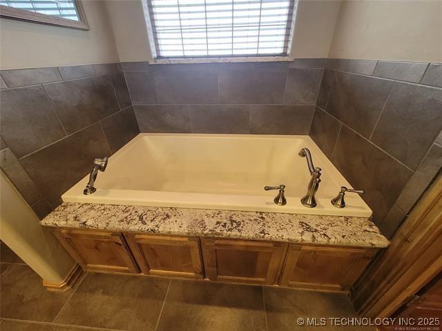 bathroom with a healthy amount of sunlight and a bath