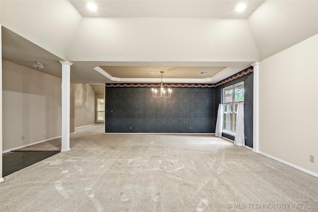 interior space featuring baseboards, carpet flooring, decorative columns, and a tray ceiling