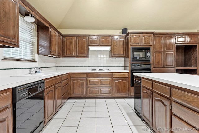 kitchen featuring a sink, light countertops, backsplash, vaulted ceiling, and black appliances