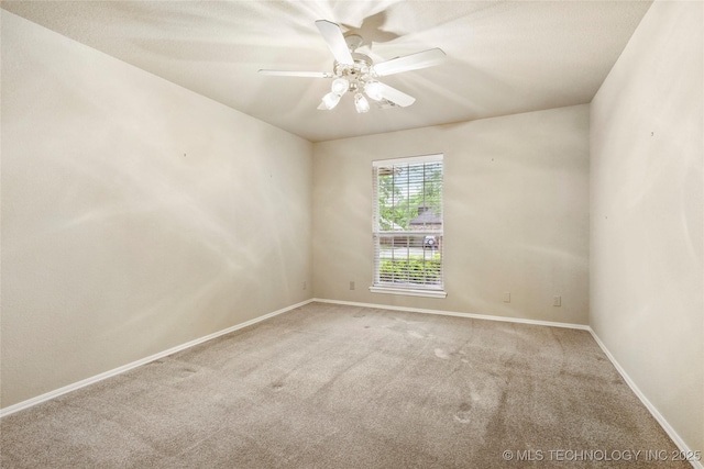 empty room with baseboards, a ceiling fan, and carpet