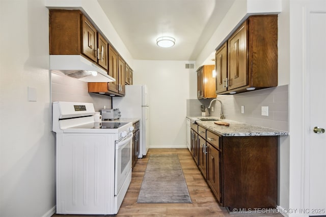 6727 S Richmond Ave Unit 632, Tulsa, OK 74136 - kitchen with electric range, under cabinet range hood, a sink, wood finished floors, and tasteful backsplash