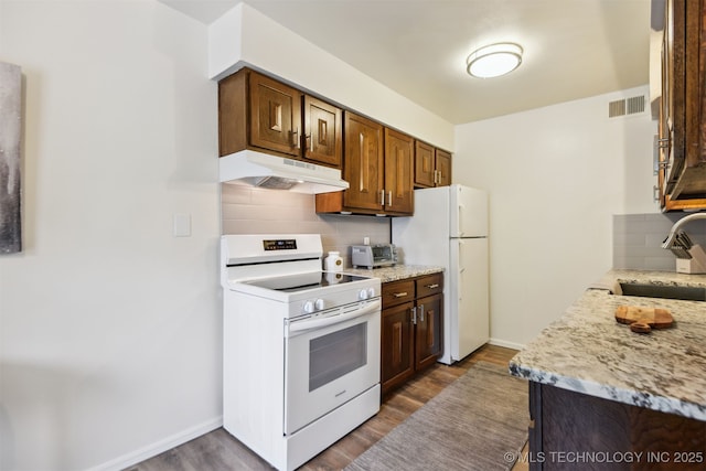 6727 S Richmond Ave Unit 632, Tulsa, OK 74136 - kitchen with white appliances, under cabinet range hood, a sink, decorative backsplash, and dark wood finished floors