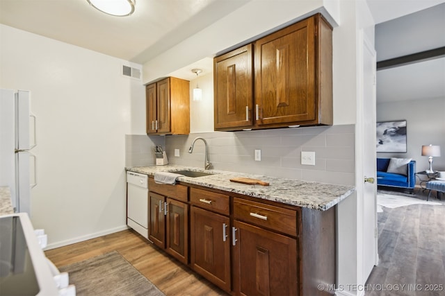 6727 S Richmond Ave Unit 632, Tulsa, OK 74136 - kitchen with white appliances, a sink, light wood-style floors, tasteful backsplash, and light stone countertops
