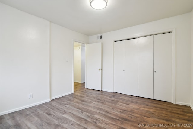 6727 S Richmond Ave Unit 632, Tulsa, OK 74136 - unfurnished bedroom with wood finished floors, baseboards, and a closet