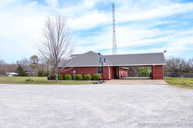 ranch-style house with brick siding, fence, driveway, and a carport