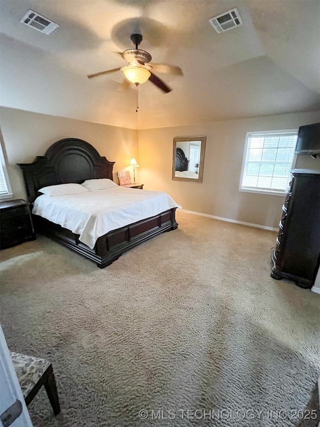 carpeted bedroom with visible vents, a ceiling fan, and baseboards